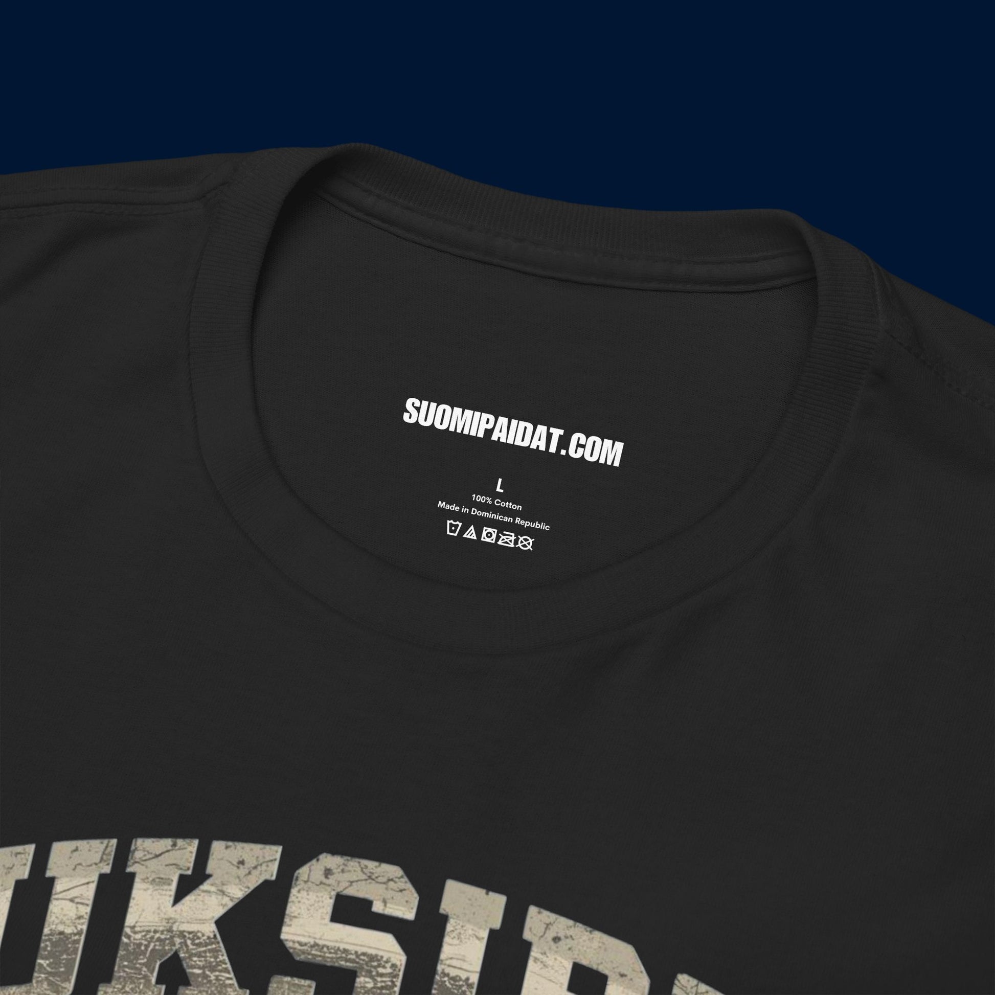 Suomipaidat.comin logolappu mustan Suksippa vittuun t-paidan sisäpuolella, 100% puuvillaa.